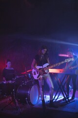 Rock group performing on illuminated stage