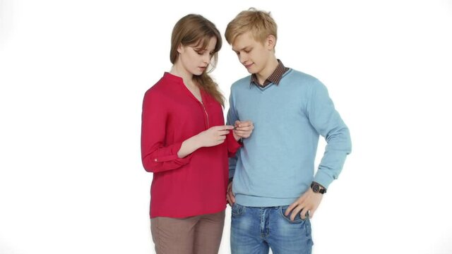 Beautiful couple on a white background. They are considering a plastic Bank card and show it to the camera