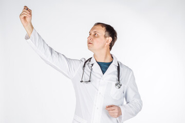 male doctor in white coat writing or drawing something imaginary with marker