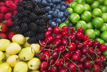Colorful harvest of summer berries and fruits. Top view and soft focus.