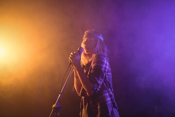 Obraz premium Female singer performing in illuminated nightclub