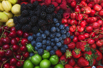 Colorful harvest of summer berries and fruits. Top view and soft focus.