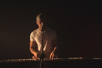 Male singer playing piano at music concert