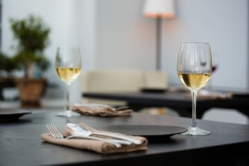 Wineglasses by eating utensils on table
