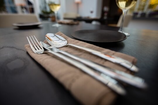 Close up of eating utensils and napkin on table