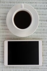 Overhead view of digital tablet by coffee cup