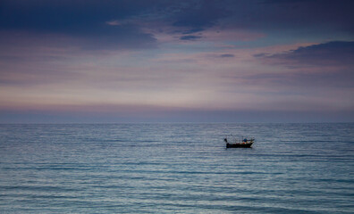 Naklejka premium A boat in a Mediterranean beach of Ionian Sea at sunset - Bova Marina, Calabria, Italy