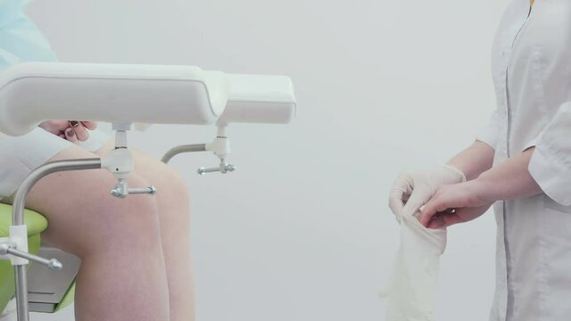 A portrait of a gynecologist put on hands the gloves