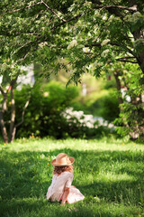 Obraz premium A girl in a hat is standing under a tree