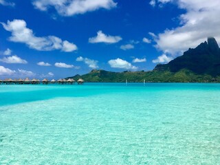 Overwater bungalows of a luxury resort in the turquoise lagoon of Bora Bora, Tahiti, French Polynesia