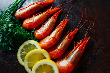 Shrimps with lemon and greens on a dark background