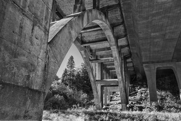Black and White Image of an Arch on a Bridge over a river