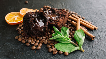 Muffin on a dark background with coffee beans and orange