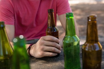 Man holding a beer bottle in the park