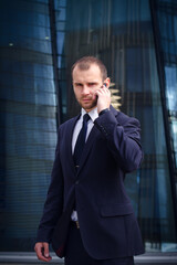 businessman talking on his cellphone while walking outdoors