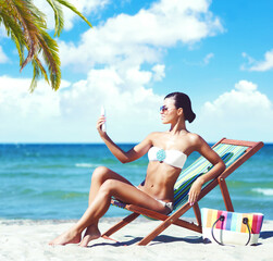 Attractive young girl in bikini sunbathing on beach. Traveling, holiday, vacation concept.