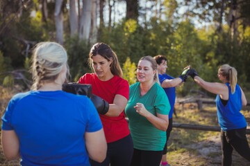 Woman practicing boxing in the boot camp