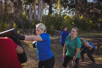 Fototapeta premium Woman practicing boxing in the boot camp