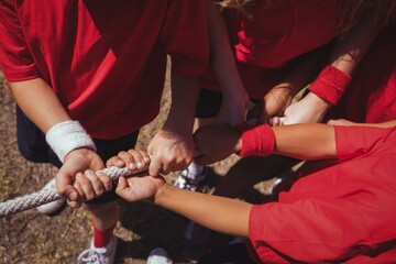 Kids playing tug of war during obstacle course training