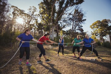 women playing tug of war during obstacle course training