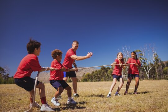 Kids playing tug of war during obstacle course training