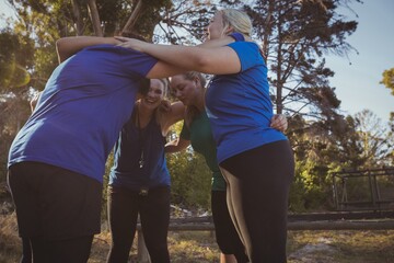 Group of women forming huddles in the boot camp