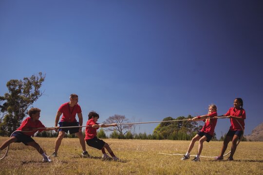 Kids playing tug of war during obstacle course training