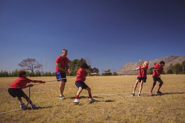 Kids playing tug of war during obstacle course training