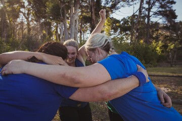 Group of fit women forming huddles in the boot camp