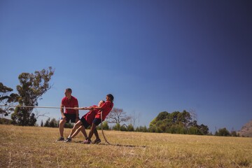 Kids playing tug of war during obstacle course training