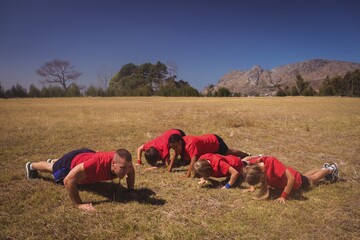 Trainer instructing kids while exercising in the boot camp
