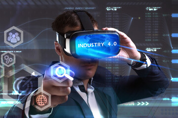 Business, Technology, Internet and network concept. Young businessman working in virtual reality glasses sees the inscription: Industry 4.0