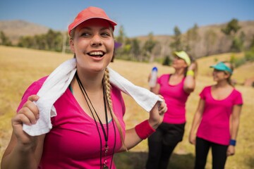 Female trainer with towel around her neck in the boot camp