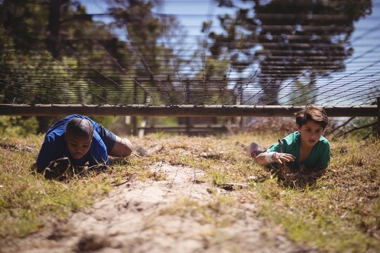 Kids crawling under the net during obstacle course