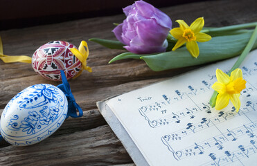 Alte, handgeschriebene Musiknoten mit bemalten Ostereiern, lila Tulpe und Narzissen, Narcissus pseudonarcissus, Frühling, Frohe Ostern  - 157860684