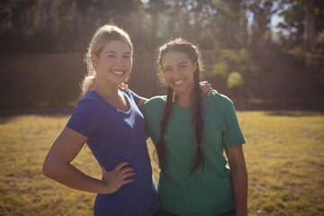 Portrait of happy friends standing in boot camp