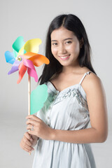 Young cute asian girl smiling with wind turbine toy