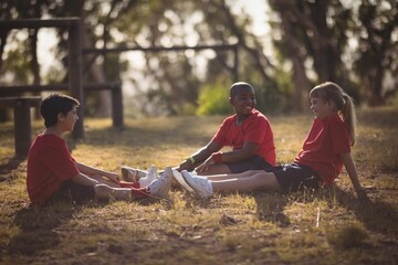 Portrait of happy kids relaxing on grass during obstacle course