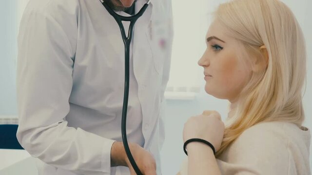 The woman is examined with a stethoscope