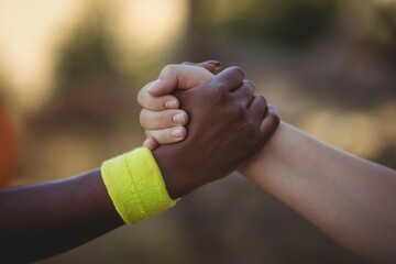 Close-up of athlete holding hands during obstacle course