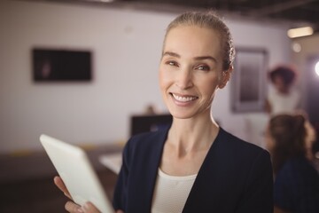 Portrait of smiling businesswoman holding digital tablet