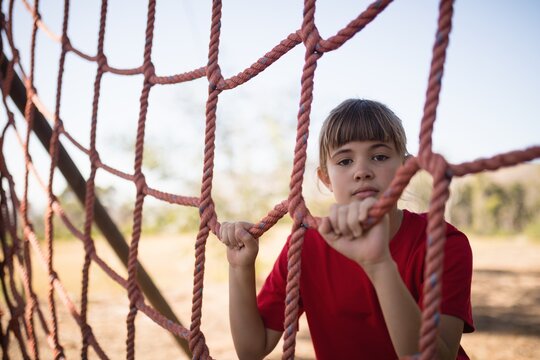 Portrait of girl standing near net during obstacle course