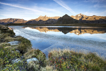 Naklejka premium Peaks TambÃ² and Piani are reflected in Lake Andossi at sunrise Chiavenna Valley Valtellina Lombardy Italy Europe