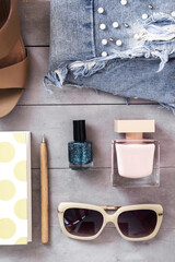 Arranged woman fashion and beauty accessories flat lay on concrete background. Top view. Blogging concept