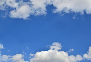 Blue sky and white fluffy clouds with a space for text - as a background