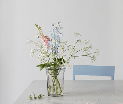 Wiesenblumen mit Kerbel und Lupinen in Glasvase auf Tisch