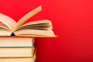 education and wisdom concept - open book on wooden table, color background