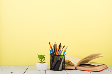 education and wisdom concept - open book on wooden table, color background