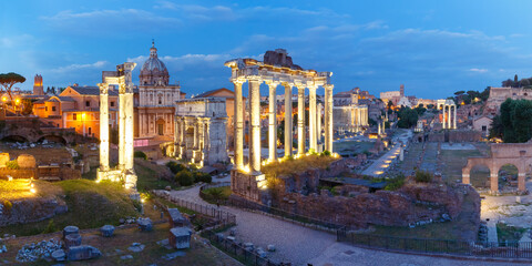 Fototapeta na wymiar Ancient ruins of a Roman Forum or Foro Romano during evening blue hour in Rome, Italy. Panoramic view from Capitoline Hill
