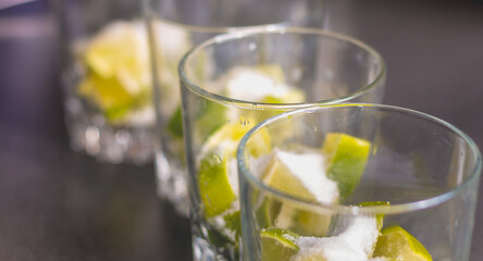 Lime cut in glasses with sugar to make caipirinhas